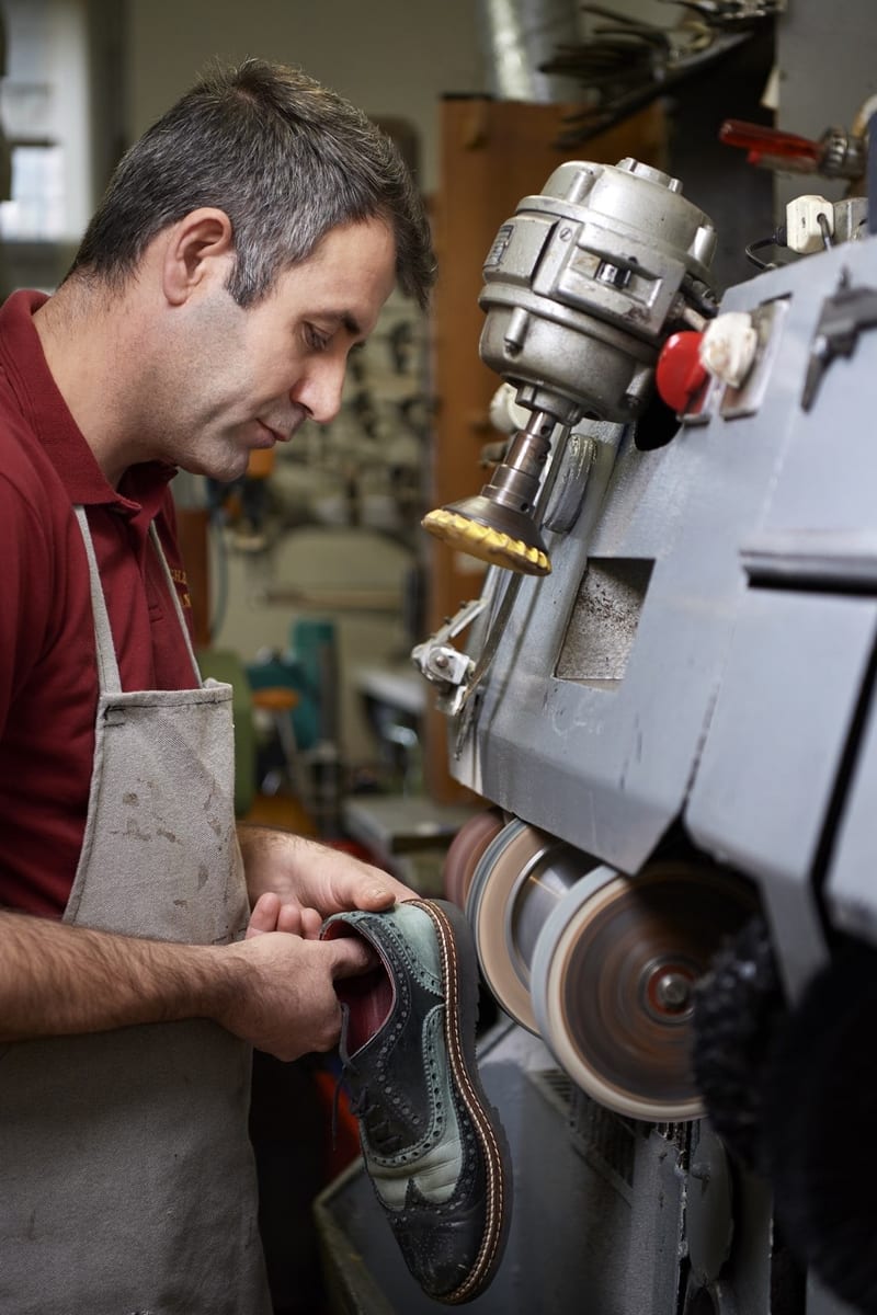 Schuhmacher Bozan bei der Reparatur eines rahmengenähten Brogues
